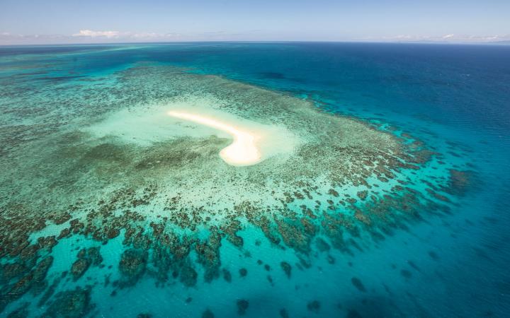Vue du ciel : une petite île et un récif de la grande barrière de corail, Australie