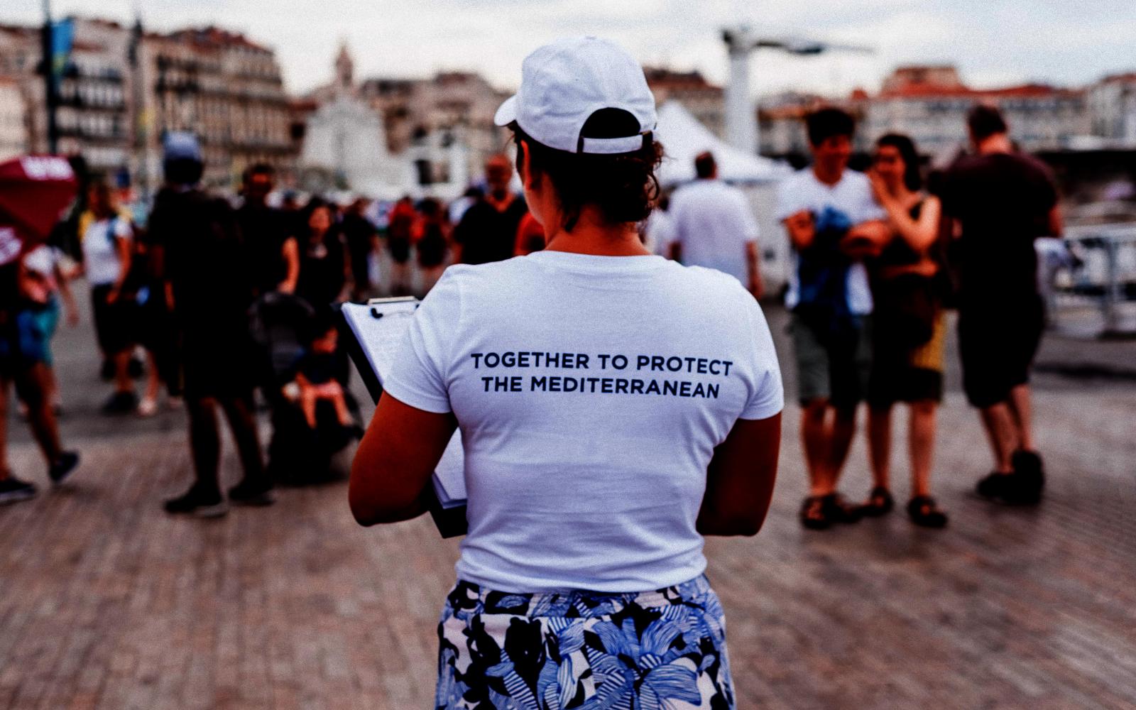 Femme de dos avec t-shirt "Together to protect the Mediterranean"